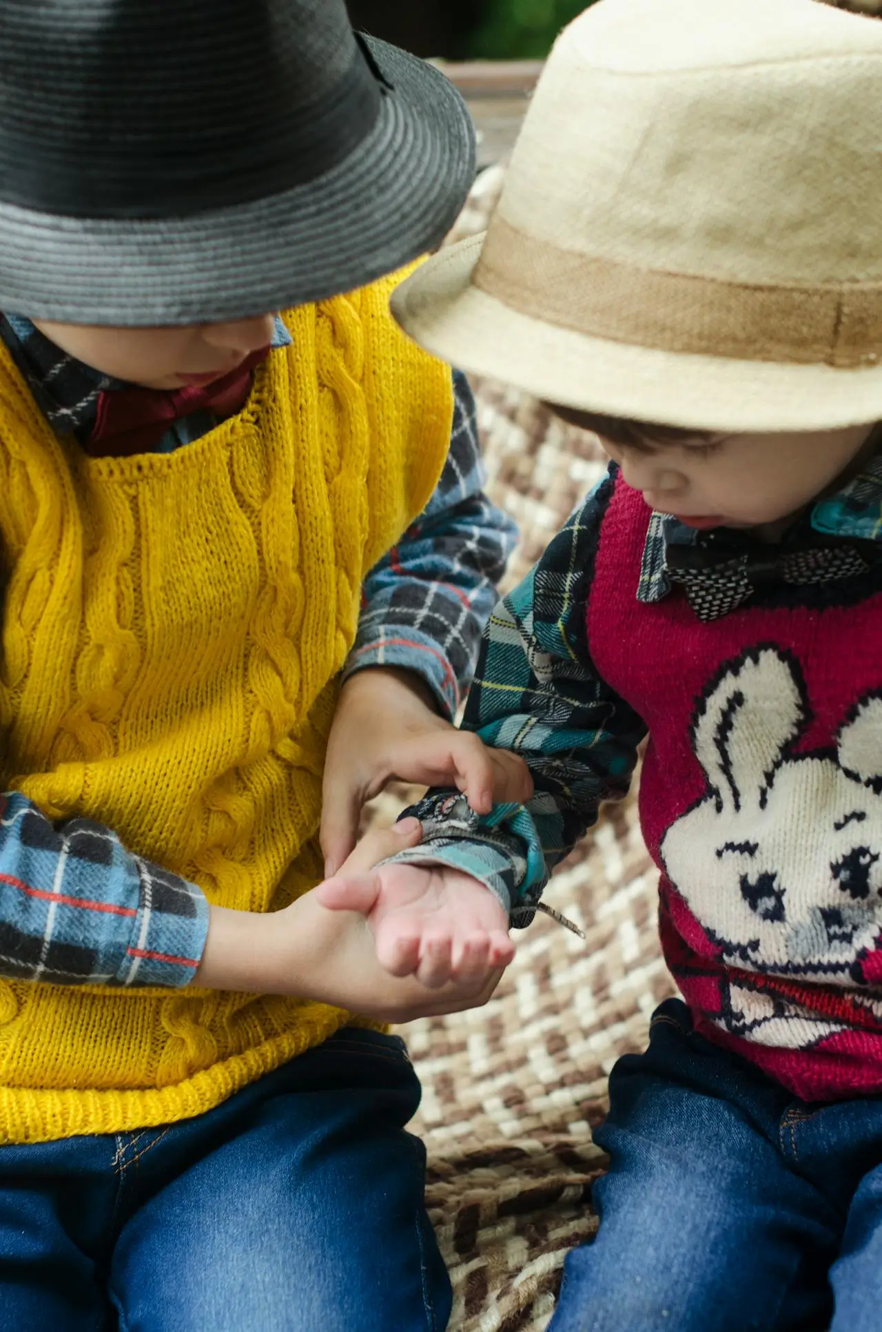 due fratellini o sorelline siedono insieme vicini e assorti nel loro mondo, a significare unione tra fratelli e sorelle