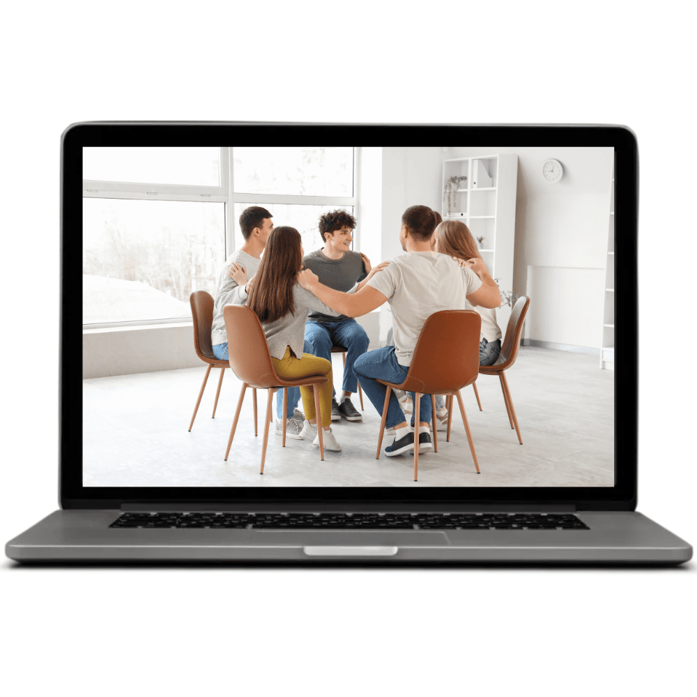 Computer portatile che mostra un gruppo di persone sedute in cerchio durante un’attività di tirocinio in costellazioni familiari.