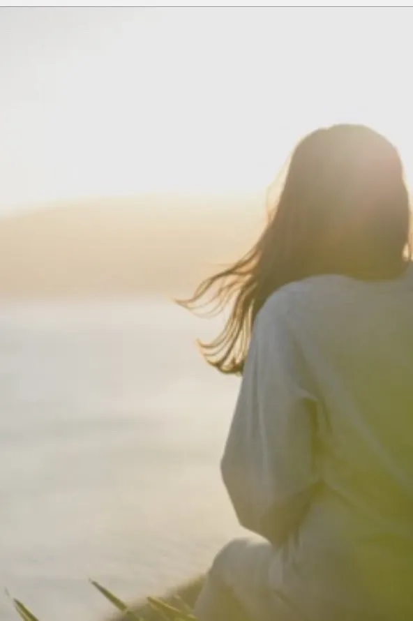 Donna in contemplazione nella luce del tramonto