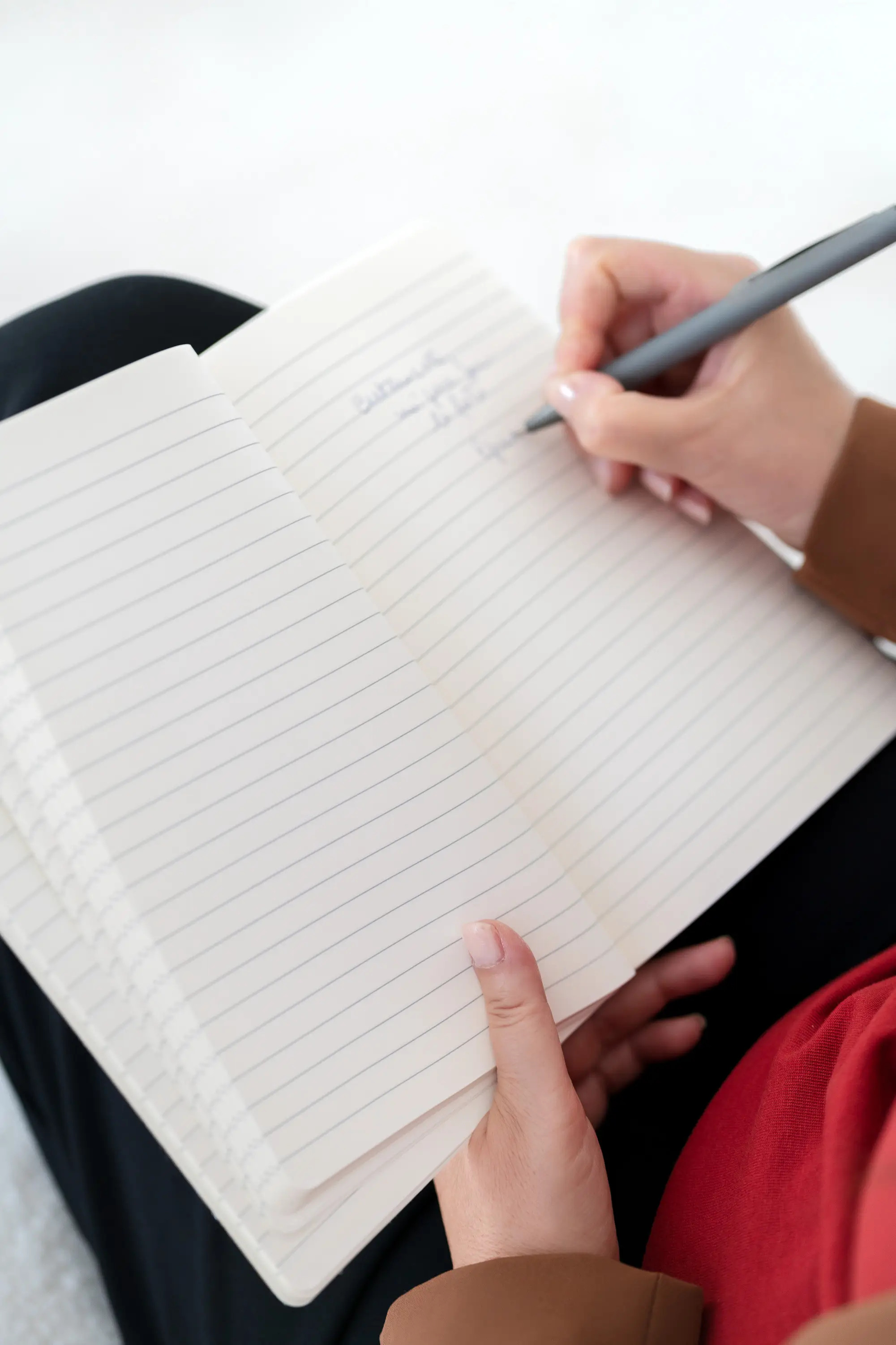 Scrittura di appunti e riflessioni su un quaderno durante un percorso di ricerca personale dedicato alla sincronicità, alle relazioni umane e ai grandi temi dell'esistenza.